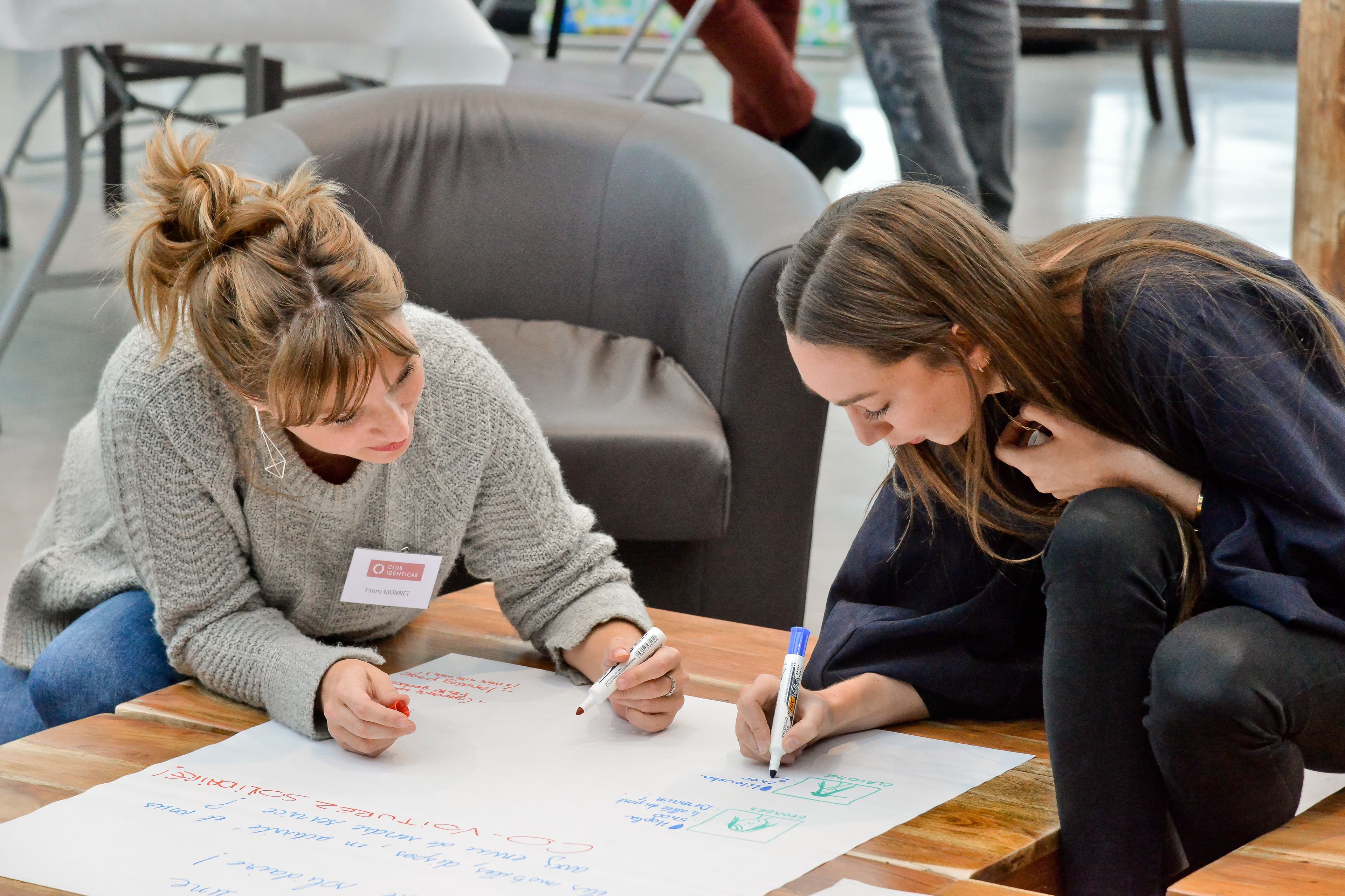 deux femmes travaillent sur une affiche